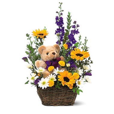 Basket of spring flowers and a teddy bear