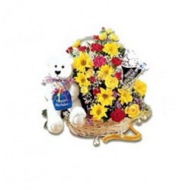 Arrangement of assorted flowers with a teddy bear