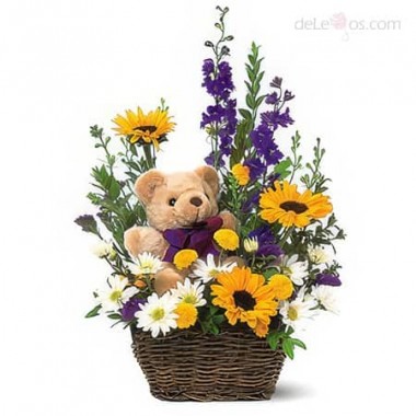 Basket of spring flowers and a teddy bear